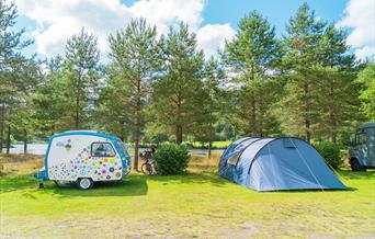 Liten søt blomstrete campingvogn og et telt