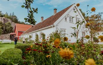 Søgne Gamle Prestegård med blomster foran