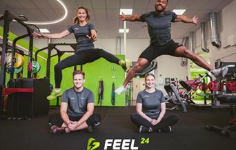 Treningsstudio, fire glade personer som poserer for kamera