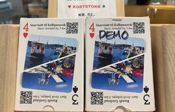 kortstokker med 52 sykkelrutekart til salgs på innbyggertorget i Arendal kultur- og rådhus