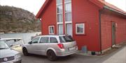 Rødt hytte med to biler parkert vedsidenav