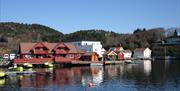 Åvik Brygge, rødt bygning med gule båter ved brygga