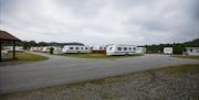 Solstrand Camping med bilde av flere hvite campingvogner på gressflekker med vei i mellom gressflekkene