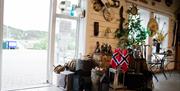 Inngangspartiet, pyntet med mange gamle tønner, kofferter, kasser. Norske småflagg, og stokker man kan kjøpe.