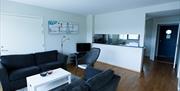 Lindesnes Havhotell - Stua til hotellrommet, et par med svarte toseter sofa.