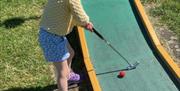 Barn som spiller minigolf