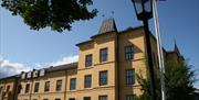 Tyholmen vidergående skole, en stor, gul borglignende murbyggning fra 1881.