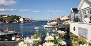 Pers brygge i bakgrunnen med blomster foran