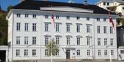 Arendal gamle rådhus sett fra sjøen. Norges høyeste og nest største bygning i empirestil. Bygget i perioden 1812-1815. Hvitt trebygg i 4 etasjer.