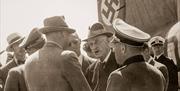 På fotoet ser vi Knut Hamsun blir tatt imot av Terboven i 1943 etter hans reise til journalistkonferansen i Wien og møtet med Adolf Hitler. Foto: Cappelen Damm.