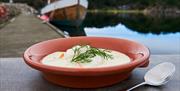 Fiskesuppe med dill til pynt i en oransje skål