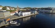 Clarion Hotel Tyholmen sett fra luften med fergeleiet på Tyholmen til venstre. Ferga Kolbjørn legger akkurat til kai.