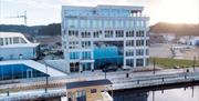 Oversiktsbilde av Mandal Hotel og badstubåten Pysen som ligger i Mandalselva