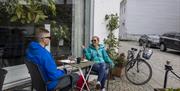 Et par som sitter å ha en pause fra sykkelturen, hos S.Kagestad kafe