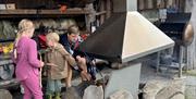 En familie griller i gapahuken på Gluba