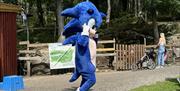 Sonic, en utkledd blå figur som hilser på barna