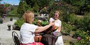 to damer tar en skål i rosehagen på Bjellandstrand Gård i Arendal
