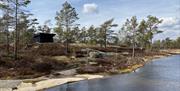 Svart gapahuk ved vannet