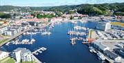 Dronebilde over Mandal gjestehavn, Mandalselva og Mandal by en solskinnsdag
