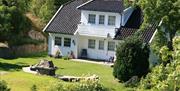 Strandhus Sandaa med fin gressplen i front