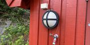 vannkran på rød vegg