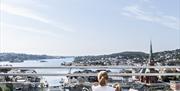 to jenter som holder rundt hverandre og ser på utsikten over Arendal by fra utsiktspunktet på Fløyheia.