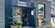 Fasade til butikken Happy homes med fine blomster på utsiden og åpen dør