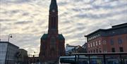 Taxiholdeplass på Sam Eydes plass i Arendal med Trefoldighetskirken i bakgrunnen.