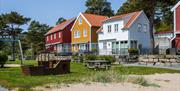 Lekeplass foran et rødt, et gult og et hvitt hus på Furuholmen