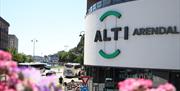 ALTI fasadelogo med Kittelsbukt i bakgrunnen