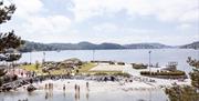 Løkholmen strand og rekreasjonsområde med badende barn og voksne