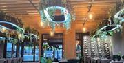 Restaurant inne med border og planter som pynt fra taket i en rolig atmosfære