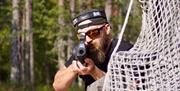 Laser tag-deltaker på TrollparkHove bak netting