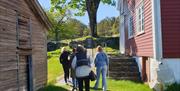 4 personer på øyvandring mellom Merdøgaard museum og loven.