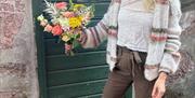 Bilde av en jente som holder en bukett med blomster