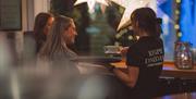 Servitør hos SMOI som serverer kaffe til gjester