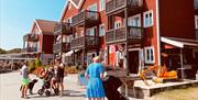 Folk som går på brygga foran Tregde marina