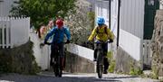 to syklende på vei opp en bratt brosteinsgate i Barbu, Arendal