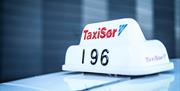 Nærbilde av Taxi Sør taxilampe på taket av en taxi.