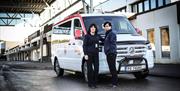 Bilde av to taxisjåfører foran en Taxi Sør bil.