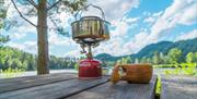 Kaffekopp og primus på et bord ute på Villmarkscamp