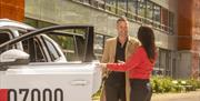 to mennesker foran hvit taxi
