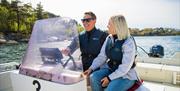 Et smilende par ute i skjærgården i en av Tregde feries utleiebåter