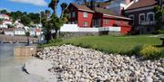 bystranda i Arendal gjestehavn med rullestein og sand