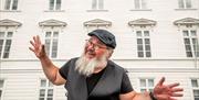 Mannlig guide som smiler foran det gamle rådhuset i Arendal