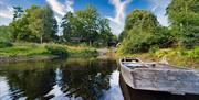 Bilde av båt på vannet med camp Flakksvann i bakgrunnen