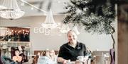 Smilende kvinne i Edgars uniform med kaffe i hendene