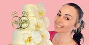 Kvinne som holder en hvit bryllups kake  med blomster detaljer