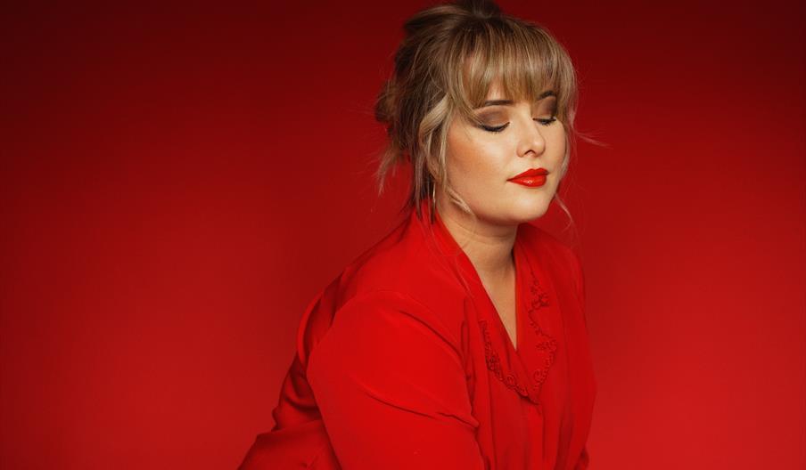 Sanger Synnøve i rødt antrekk mot rød bakgrunn – pressebilde til konserten «Synnøve (Blues/Soul)» på Byremo Scene Sanger Synnøve i rødt antrekk mot rød bakgrunn – pressebilde til konserten «Synnøve (Blues/Soul)» på Byremo Scene